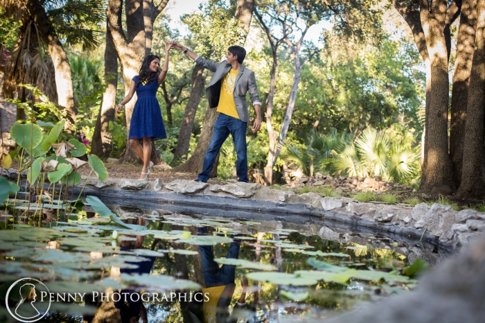 couple dancing by a pond in a garden during engagement portraits