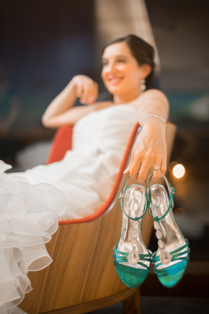 bride holding her blue shoes