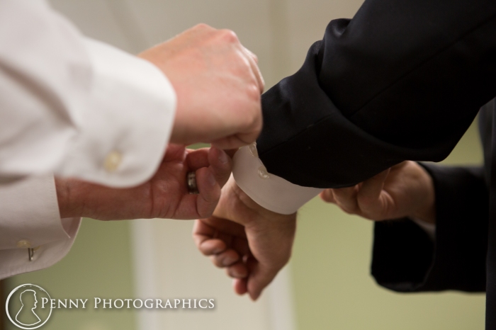 brother helps groom with cufflinks